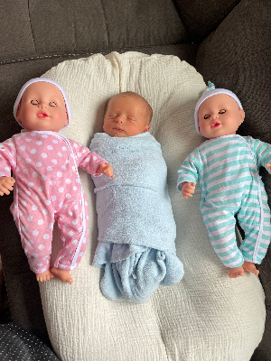 Our tiny guy with his sisters dolls